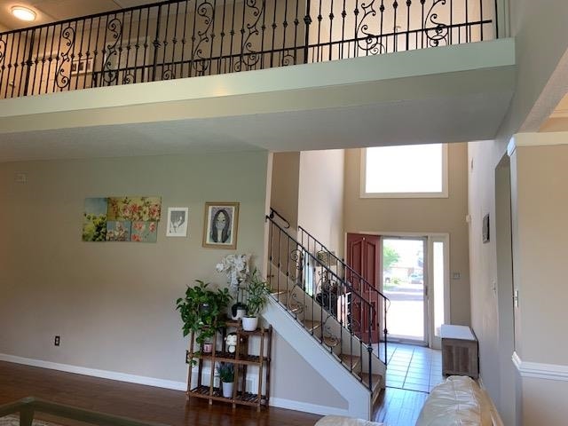 stairs with a high ceiling and hardwood / wood-style floors