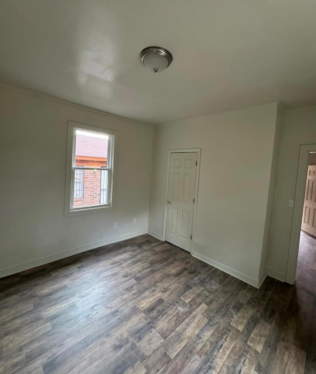 empty room with dark hardwood / wood-style flooring