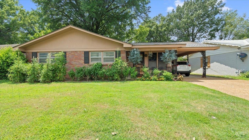 ranch-style home featuring a carport and a front lawn