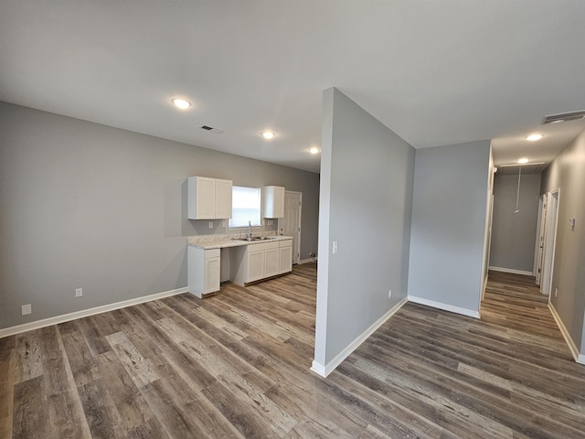 kitchen with visible vents, white cabinetry, dark wood-type flooring, and a sink