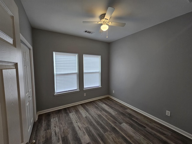 unfurnished bedroom featuring a ceiling fan, dark wood-style floors, visible vents, and baseboards