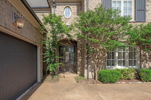 entrance to property featuring a garage and french doors