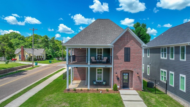 view of front of house featuring a balcony, cooling unit, and a front yard