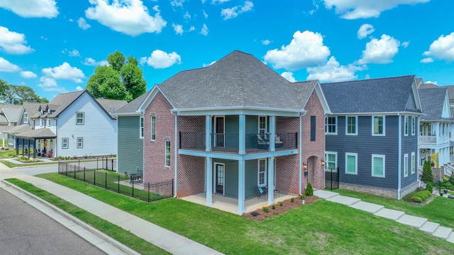 view of front of house with a balcony and a front yard