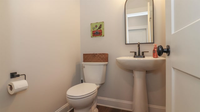 bathroom featuring hardwood / wood-style flooring and toilet