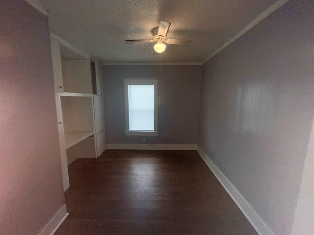 unfurnished room featuring ornamental molding, dark wood-style flooring, ceiling fan, and baseboards