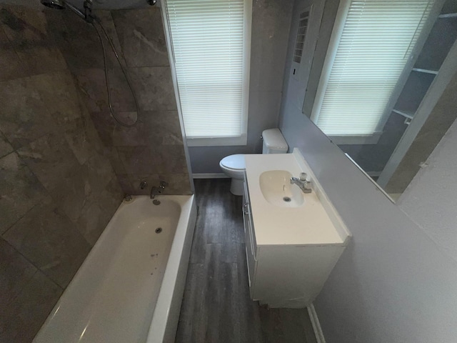 full bathroom with baseboards, toilet, wood finished floors,  shower combination, and vanity