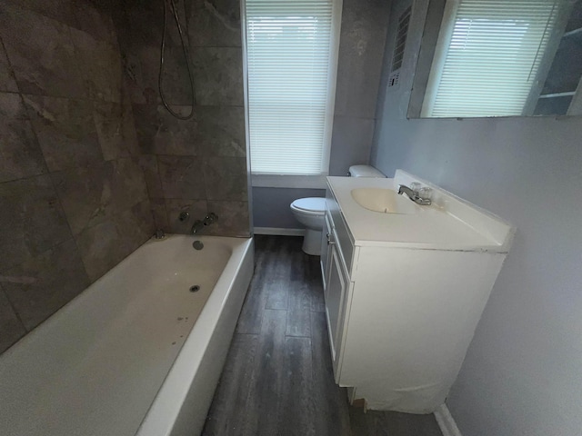 full bath with toilet, wood finished floors, vanity, baseboards, and tub / shower combination