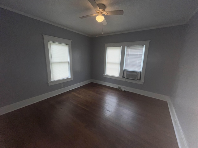 empty room featuring baseboards, ornamental molding, dark wood-style flooring, and a wealth of natural light