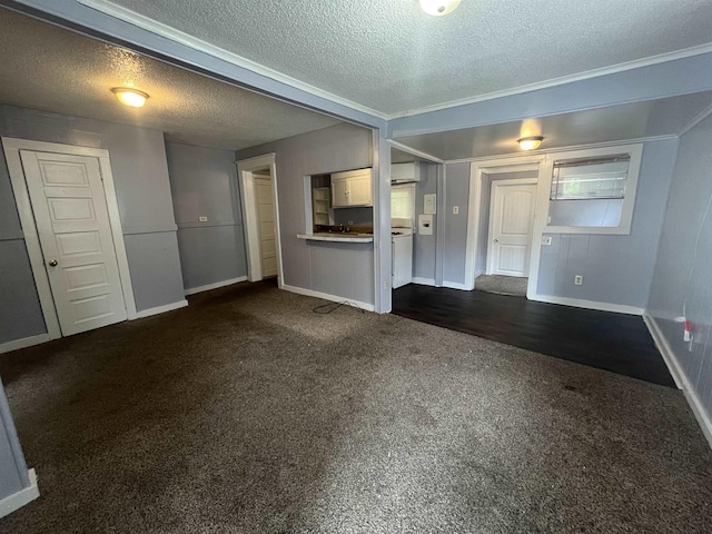 unfurnished living room featuring baseboards, dark carpet, and a textured ceiling