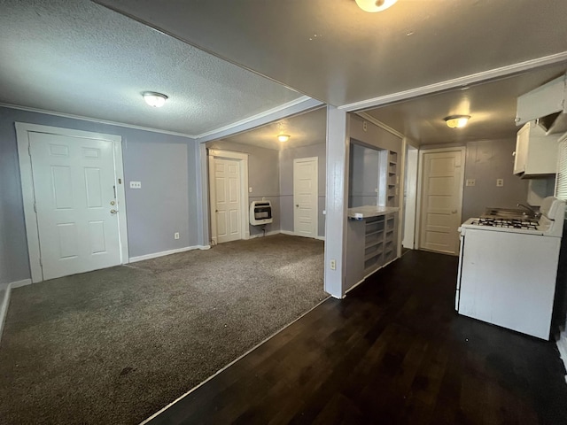 interior space featuring a textured ceiling, dark wood-style flooring, heating unit, dark colored carpet, and crown molding