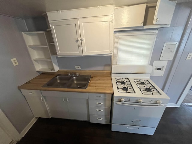 kitchen with butcher block countertops, white cabinets, a sink, and white range with gas cooktop