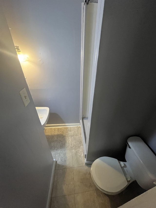 bathroom with toilet and tile patterned floors