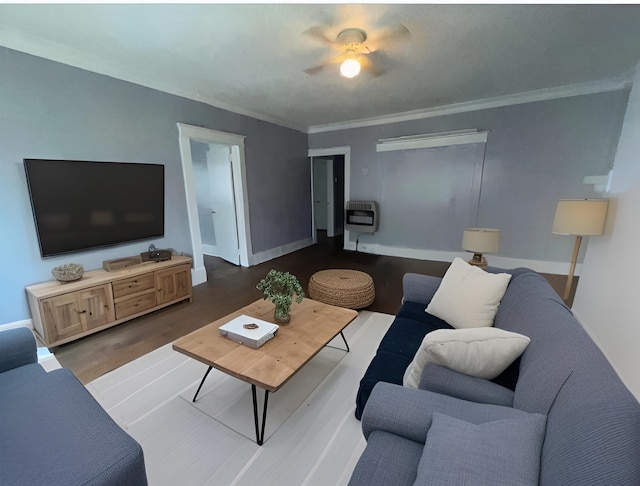 living room featuring baseboards, ornamental molding, dark wood-type flooring, and heating unit