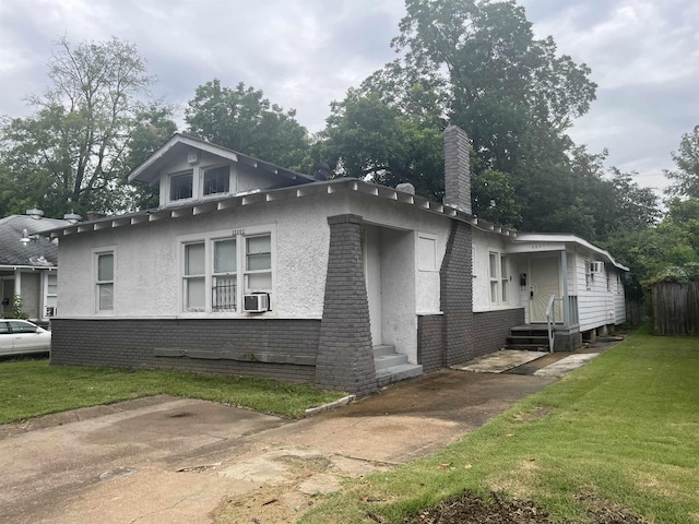 view of side of home with entry steps, brick siding, and a yard