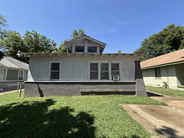 back of house with cooling unit, brick siding, fence, a lawn, and stucco siding