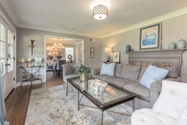 living room featuring ornamental molding, dark wood-type flooring, and a chandelier