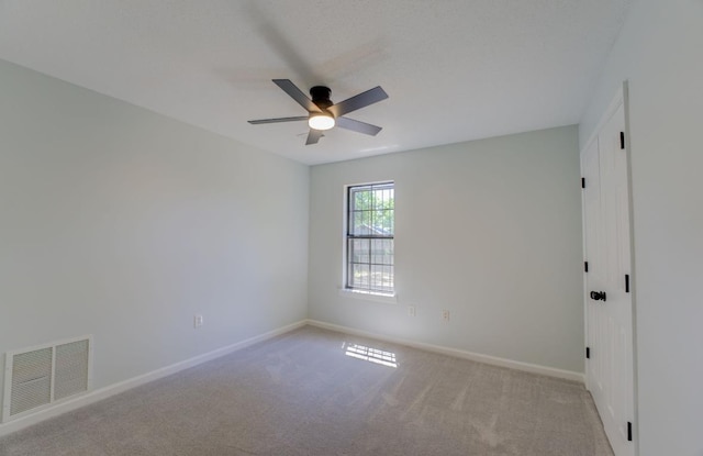 unfurnished room with ceiling fan and light colored carpet