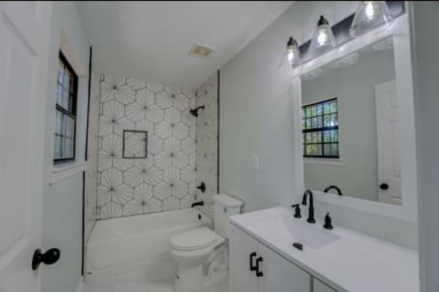 full bathroom featuring toilet, tiled shower / bath, and vanity