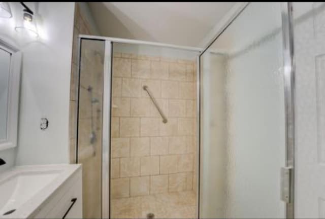 bathroom featuring vanity and a shower with door