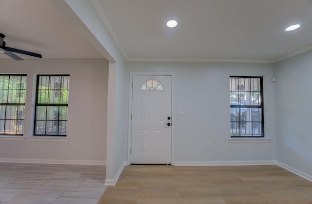 foyer featuring ceiling fan and ornamental molding