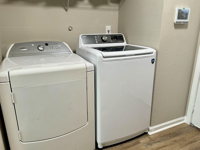 laundry room featuring washer and dryer and wood-type flooring