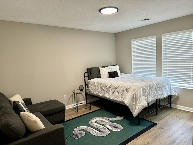 bedroom featuring hardwood / wood-style flooring and a textured ceiling