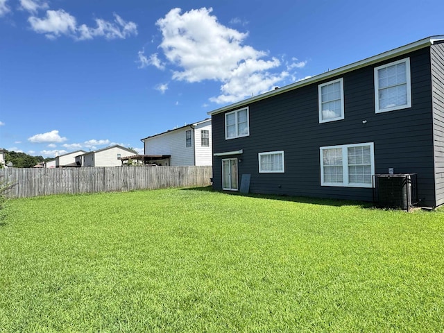 rear view of house featuring a lawn and cooling unit