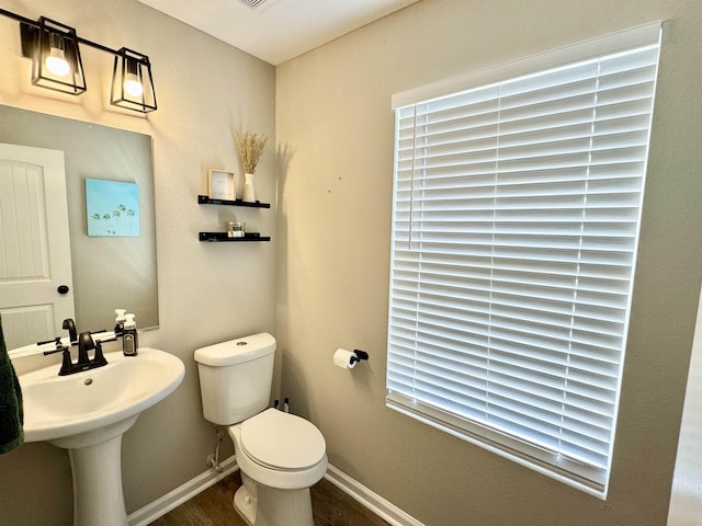 bathroom with toilet and wood-type flooring