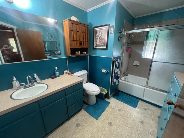 full bathroom featuring crown molding, combined bath / shower with glass door, toilet, a textured ceiling, and vanity