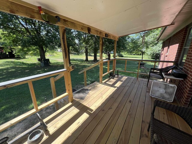 wooden deck featuring a lawn