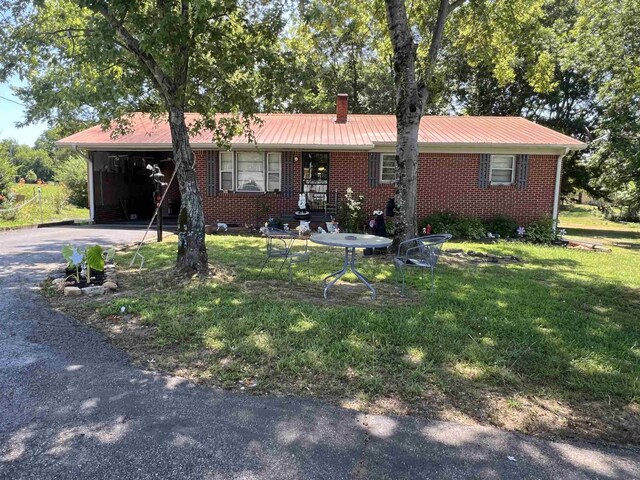 ranch-style home featuring a front yard and a carport