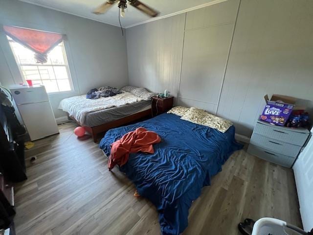 bedroom featuring hardwood / wood-style flooring, ceiling fan, and crown molding