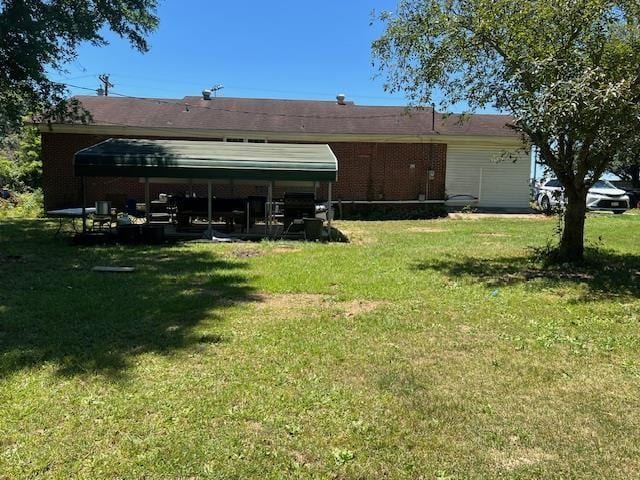 rear view of house featuring a yard and a carport