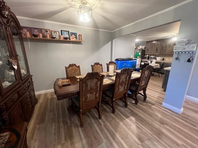 dining space with crown molding and wood-type flooring