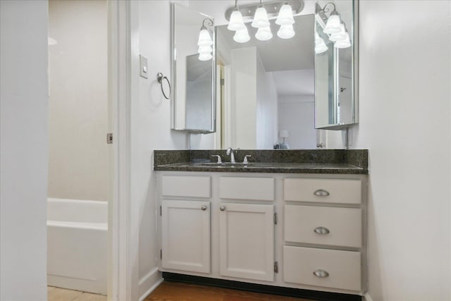 bathroom featuring wood-type flooring, vanity, and bathing tub / shower combination