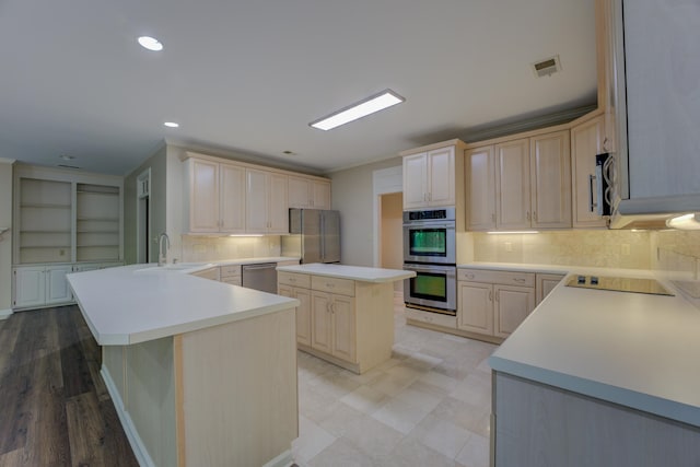 kitchen with a kitchen island, stainless steel appliances, light hardwood / wood-style floors, decorative backsplash, and sink