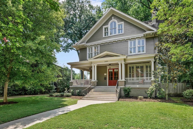 view of front of property with french doors, a porch, and a front lawn