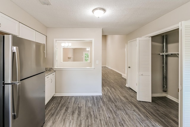 kitchen featuring dark hardwood / wood-style floors, stainless steel fridge, a textured ceiling, and white cabinets