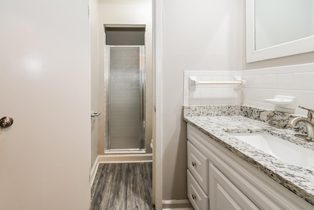 bathroom featuring walk in shower, vanity, and hardwood / wood-style floors