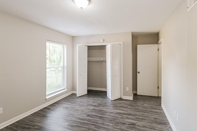 unfurnished bedroom featuring dark wood-type flooring and a closet