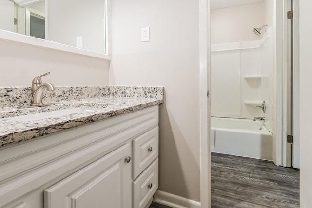 bathroom with vanity, hardwood / wood-style flooring, and  shower combination