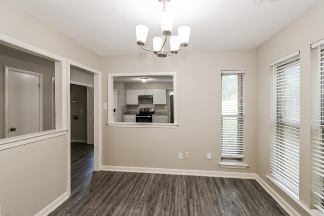 unfurnished dining area with an inviting chandelier and dark hardwood / wood-style flooring