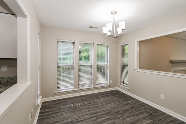 unfurnished dining area with dark wood-type flooring and a chandelier