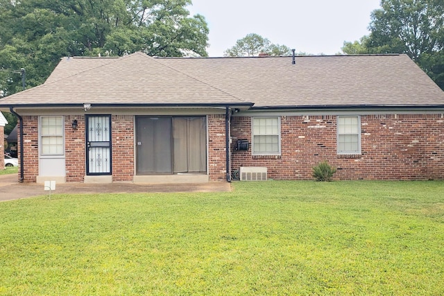 rear view of house featuring a lawn and central AC