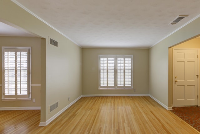 unfurnished room featuring ornamental molding and light hardwood / wood-style flooring