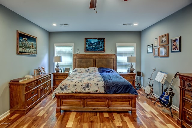 bedroom with multiple windows, ceiling fan, and light hardwood / wood-style flooring