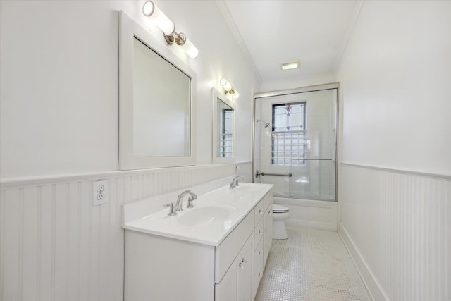 full bathroom featuring tile patterned floors, ornamental molding, bath / shower combo with glass door, vanity, and toilet