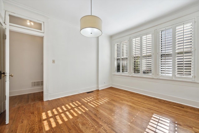 spare room with wood-type flooring and ornamental molding