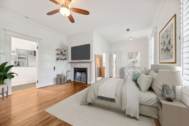 bedroom featuring hardwood / wood-style flooring, ceiling fan, and crown molding